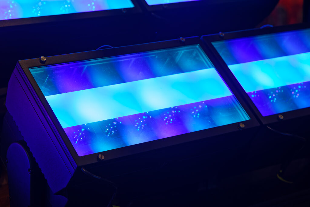 Cool toned lights illuminating a dark room with the middle of three rows covered by a frost filter. 